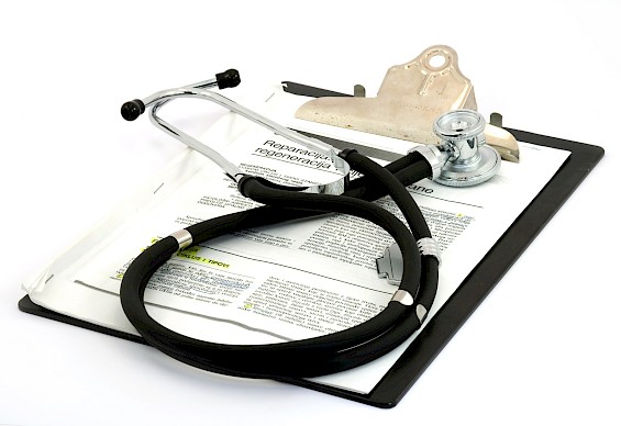 Clipboard with urgent care paper documents with a stethoscope laying on top.