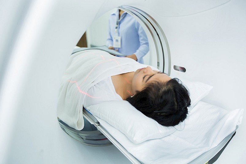 A woman laying on her back and entering a MRI machine at HealthCARE Express